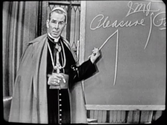 Bishop Sheen writing at the blackboard during a broadcast