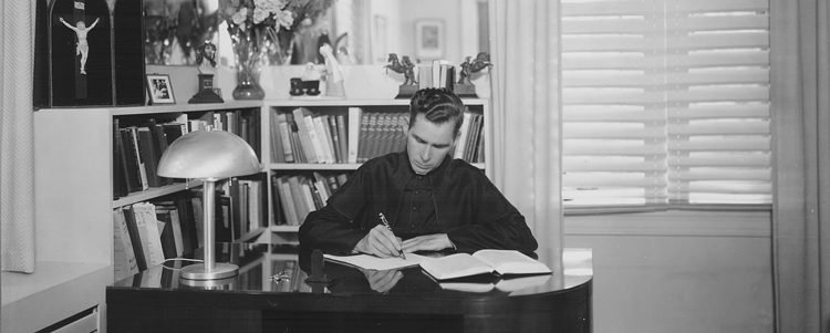 Monsignor Sheen writing at his desk in Washington