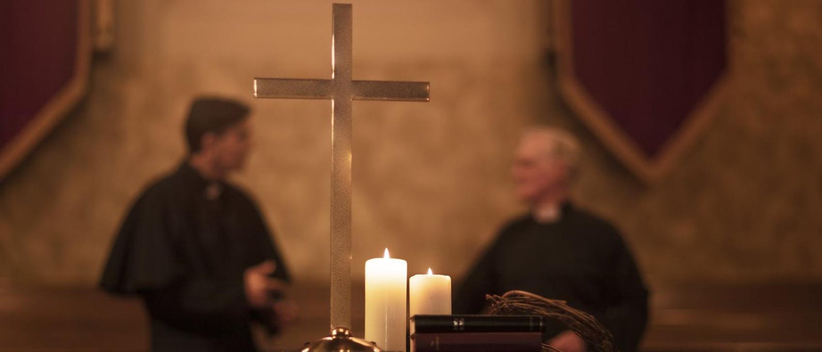 A cross and lit candles on an altar