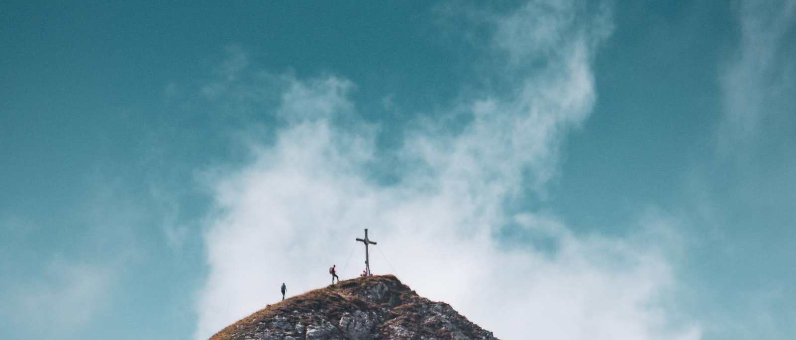 A cross on a mountain summit at dawn
