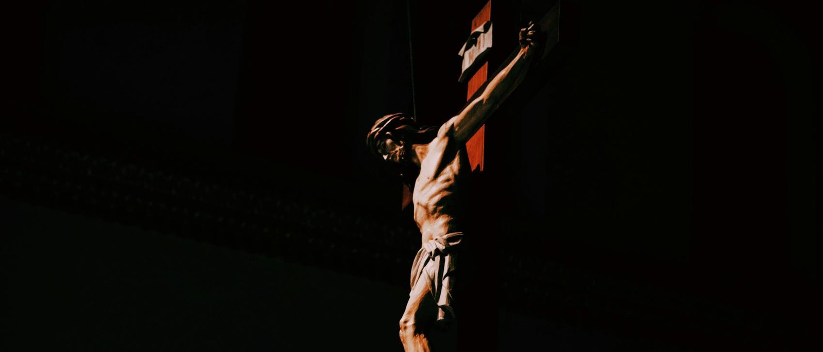 A carved crucifix lit in a dark church