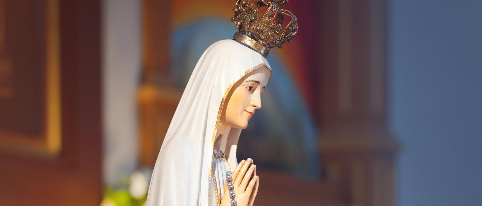 A statue of Our Lady with a rosary