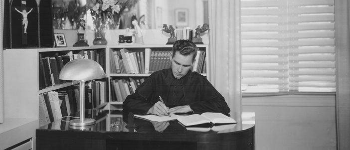Monsignor Sheen writing at his desk
